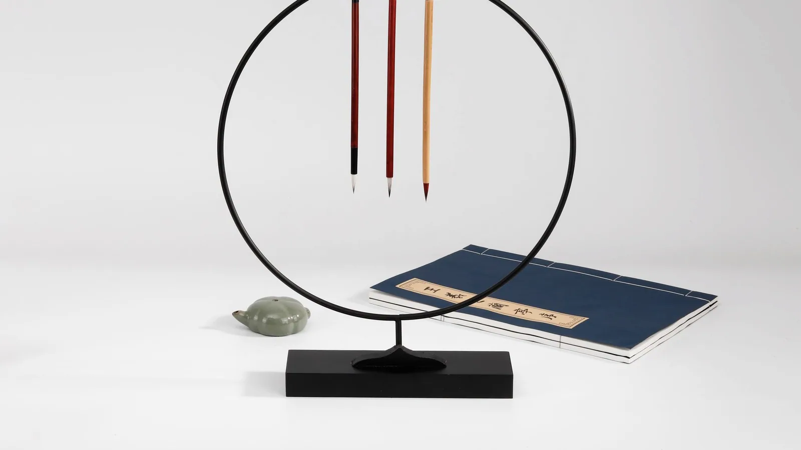 円形の展示架に太さの異なる三本の筆を並べた構成